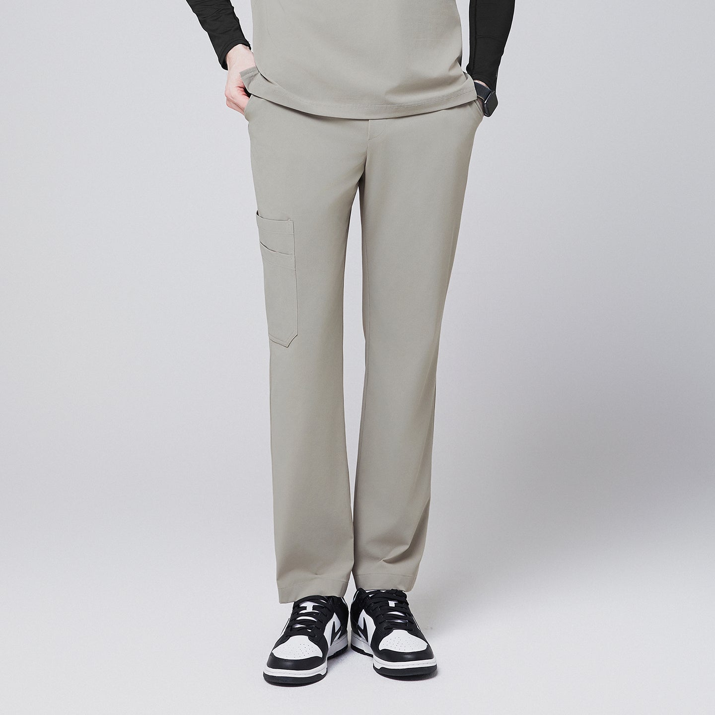 Image of Sand khaki straight-leg scrub pants with a side pocket, paired with a matching top and black-and-white sneakers,Sand Khaki
